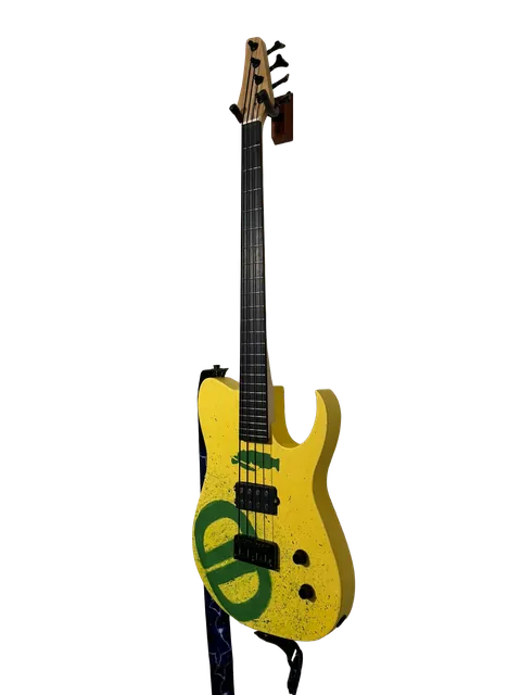 Yellow bass guitar with a green painted design, standing upright.