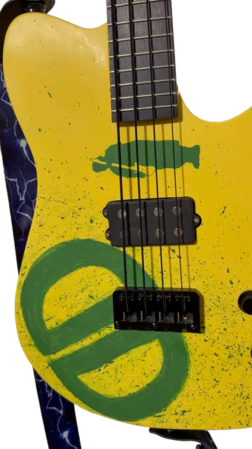 Close-up of the yellow bass body with green painted artwork and two pickups.
