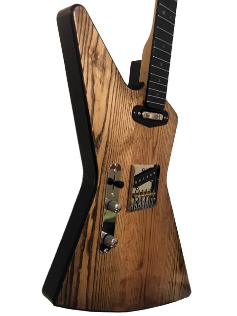 Angled side view of the explorer-shaped guitar showing the wood grain.