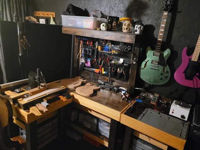 Another view of the shop's benches, tool wall and hanging guitars.